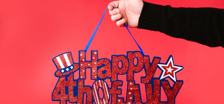 A hand holding a glittery 'Happy 4th of July' sign against a vibrant red background.